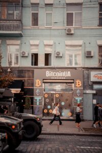 Busy city street with people passing by a Bitcoin exchange shop.